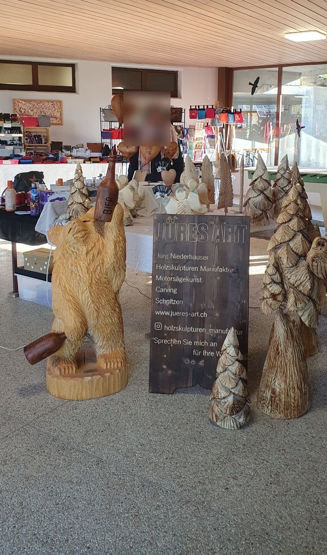 Stand von Jüres Art mit Bär, Tannen, Herzen und Federn in einer Markthalle