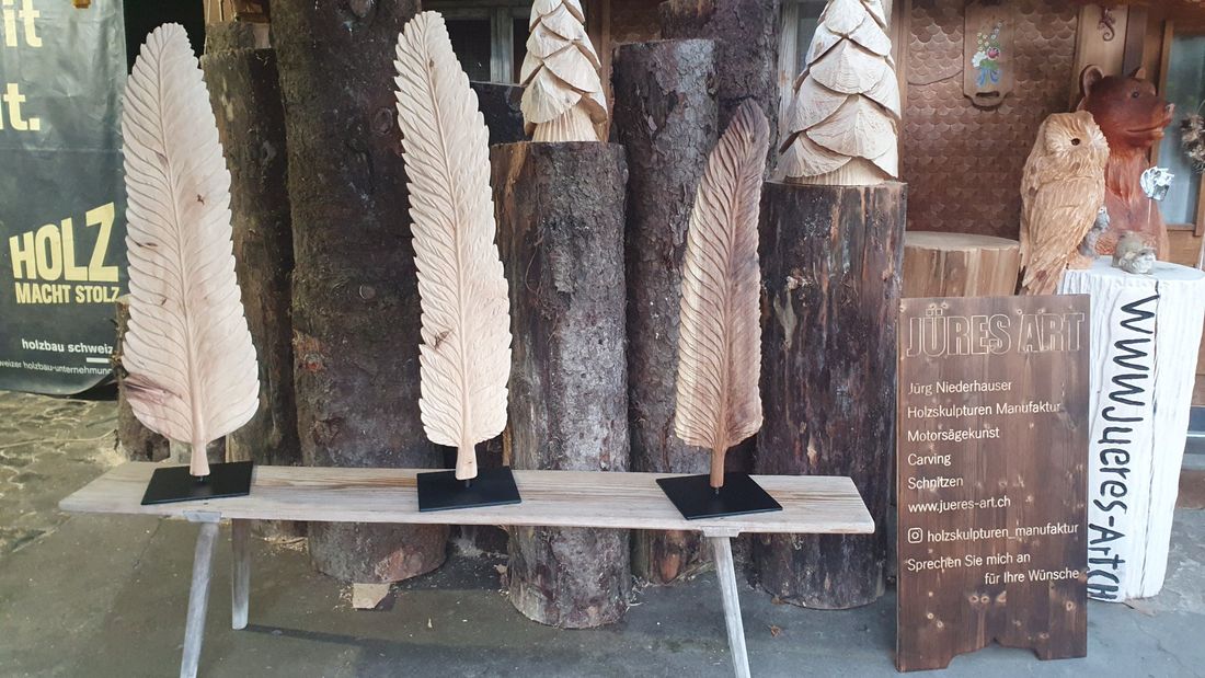 Drei Federn auf der Bank aus Holz