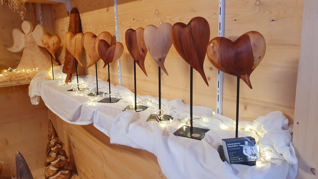 Herzen aus Holz in verschiedenen Holzarten auf Ständern